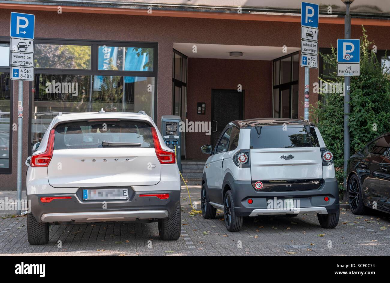 Ligier Myli, Mopedauto, Höchstgeschwindigkeit bis 45 km/h, Leichtwagen, MiniFahrzeug, kann man mit dem Mopedführerschein, Klasse AM, ab 15 Jahren fahren, Elektrofahrzeug, lädt an einer Ladestation, daneben ein normales E-auto, beim Ladevorgang, Mopedauto *** Ligier Myli, voiture cyclomotrice, vitesse maximale jusqu'à 45 km h, véhicule léger, mini Banque D'Images
