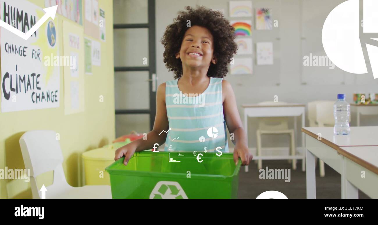Enfant debout présentant un bac de recyclage vert dans la salle de classe de l'école, avec des affiches de sensibilisation au climat Banque D'Images