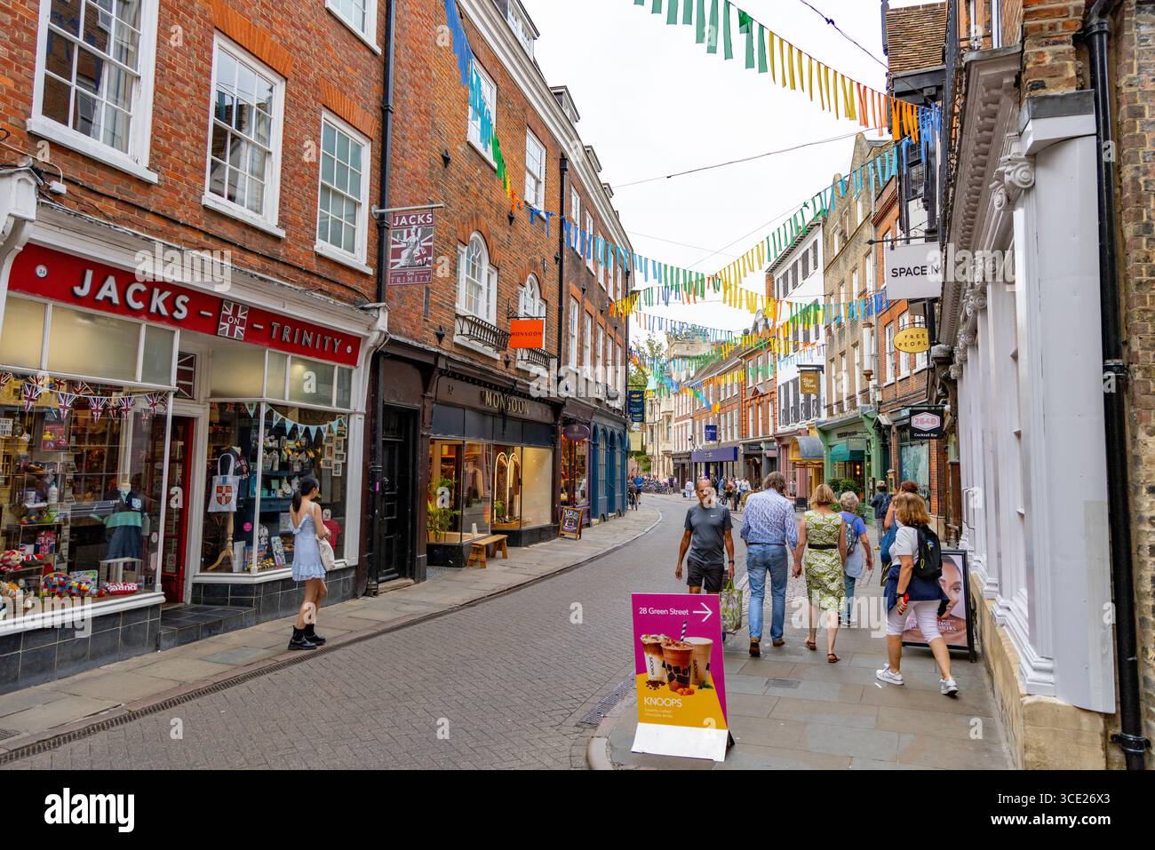Trinity Street, centre-ville de Cambridge, Angleterre, rue bordée de guirlande et de magasins et magasins avec des gens shopping, Royaume-Uni Banque D'Images
