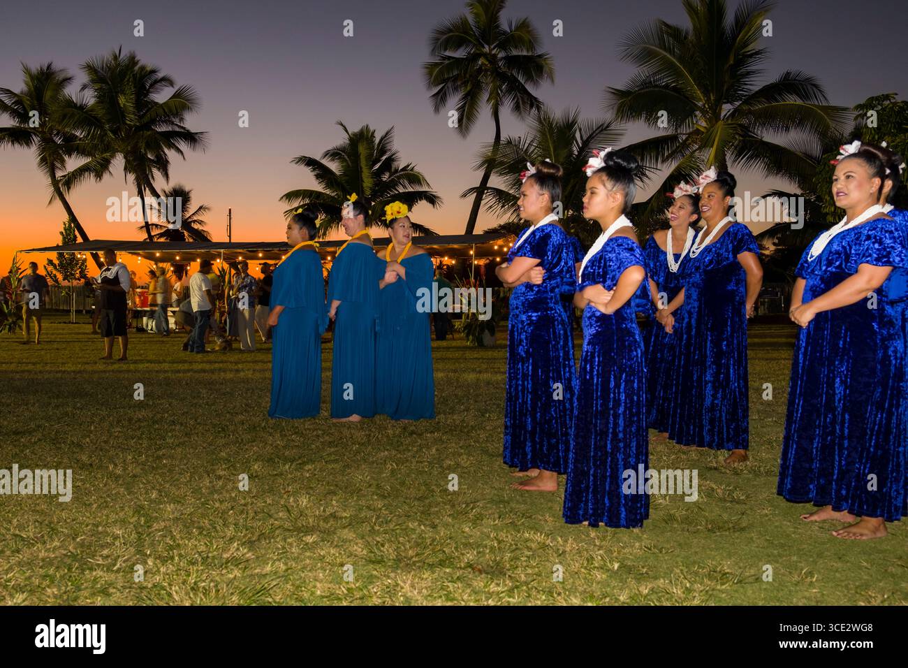 Les femmes portant des robes en velours bleu debout sur pelouse avant leur performance hula, Kekaha Harbour House, Waimea, Kauai, Hawaii, USA Banque D'Images
