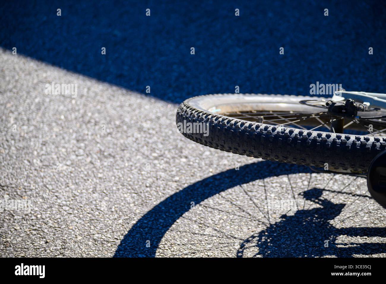 Roue de vélo et ombre au sol, un concept de voyage urbain Banque D'Images