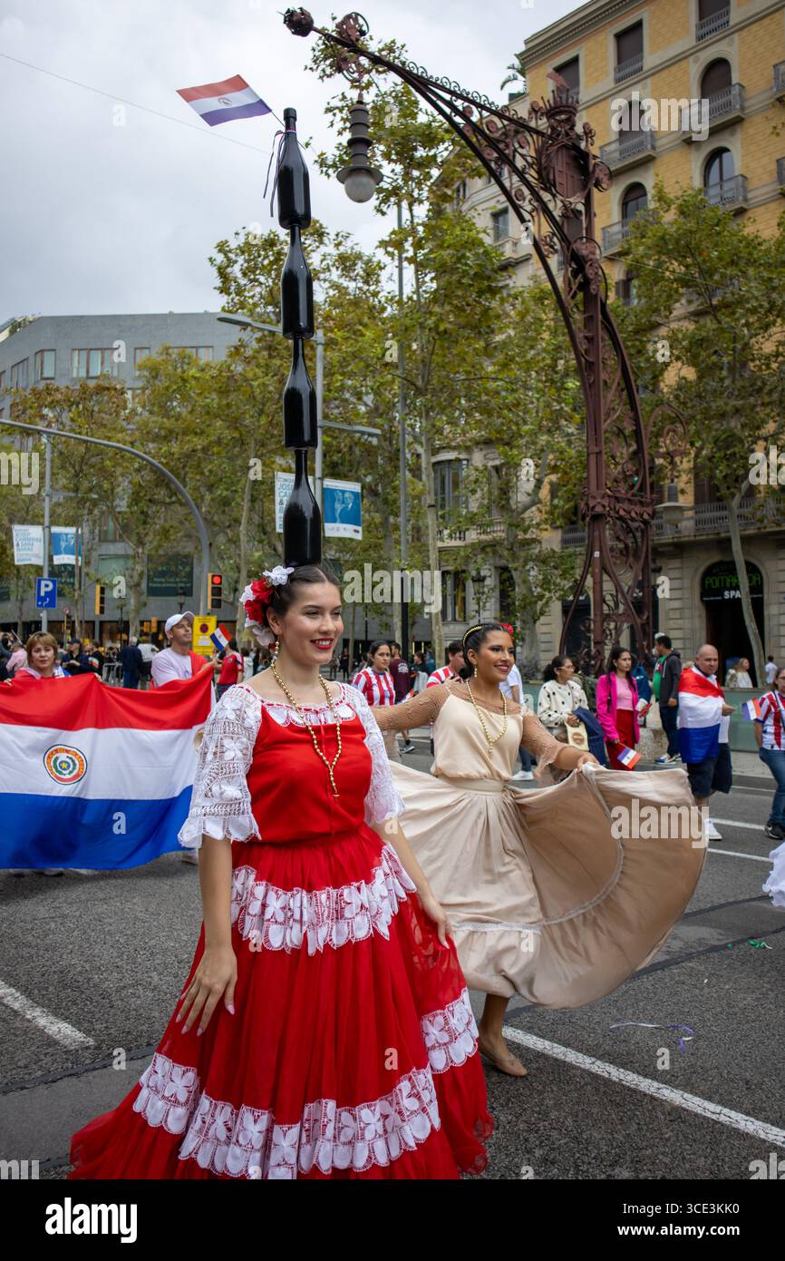12 octobre 2024, Barcelone (Espagne). Les membres d'un groupe folklorique portant des costumes traditionnels multicolores posent lors de la Journée hispanique à Barcelone. Banque D'Images