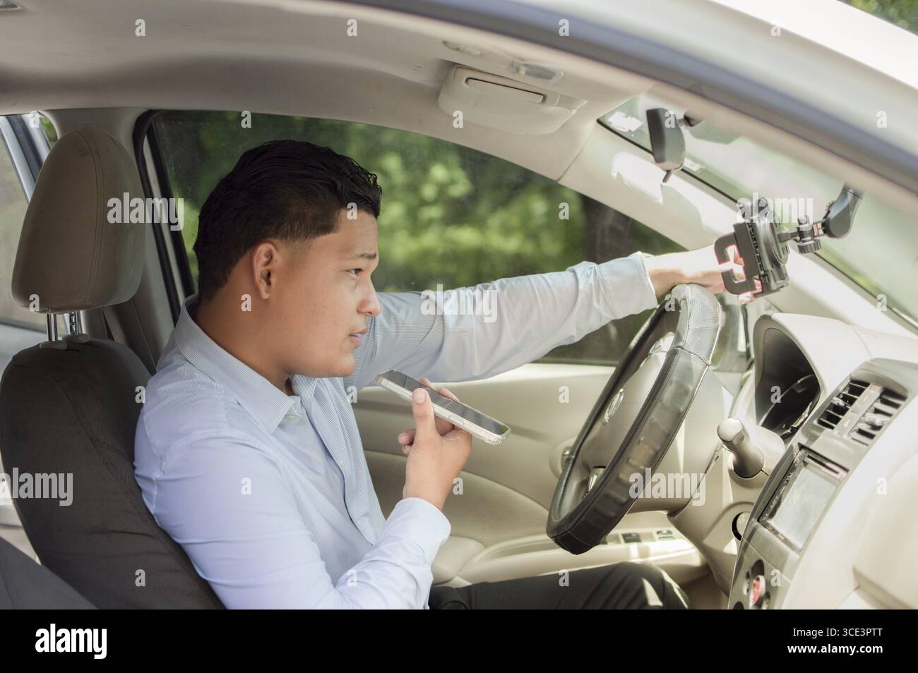 Jeune conducteur parlant pendant un appel en conduisant Banque D'Images