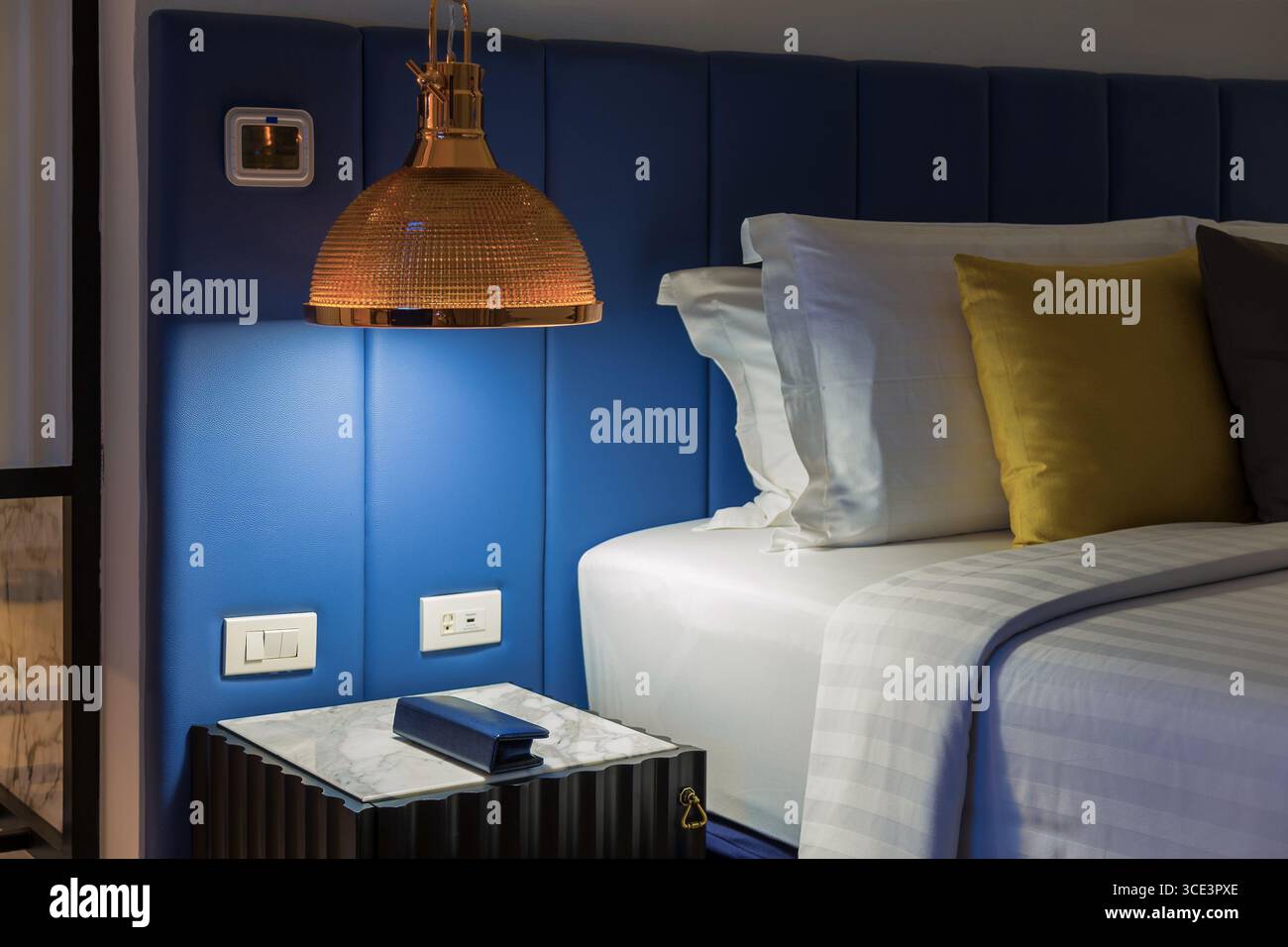 Lampe suspendue moderne avec interrupteurs sur la table d'appoint dans l'hôtel de chambre. Banque D'Images