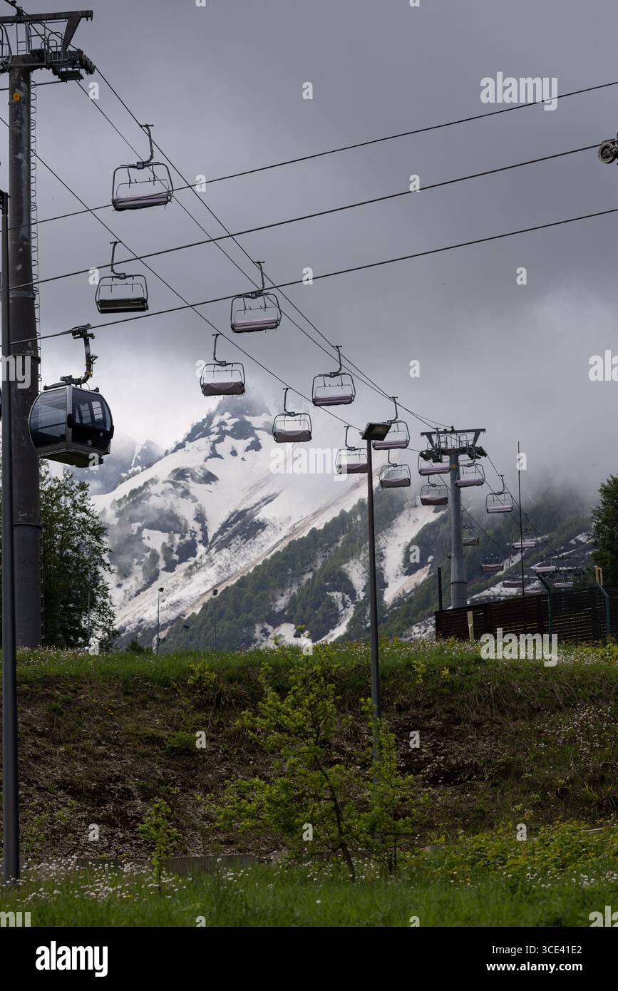 Télésièges à la station de ski. Les montagnes et les pentes de neige sont visibles. Le temps est nuageux. Banque D'Images