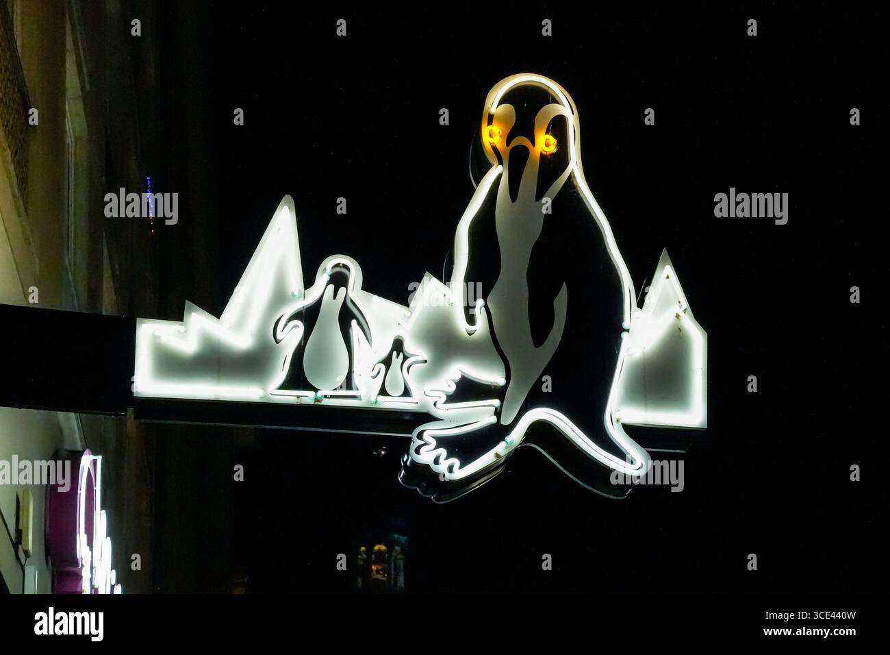 Une famille de pingouins. Enseigne lumineuse au néon du Milchbar Pinguin, Katharinenstraße, Leipzig. Enseigne historique au néon de l'époque de la RDA Banque D'Images