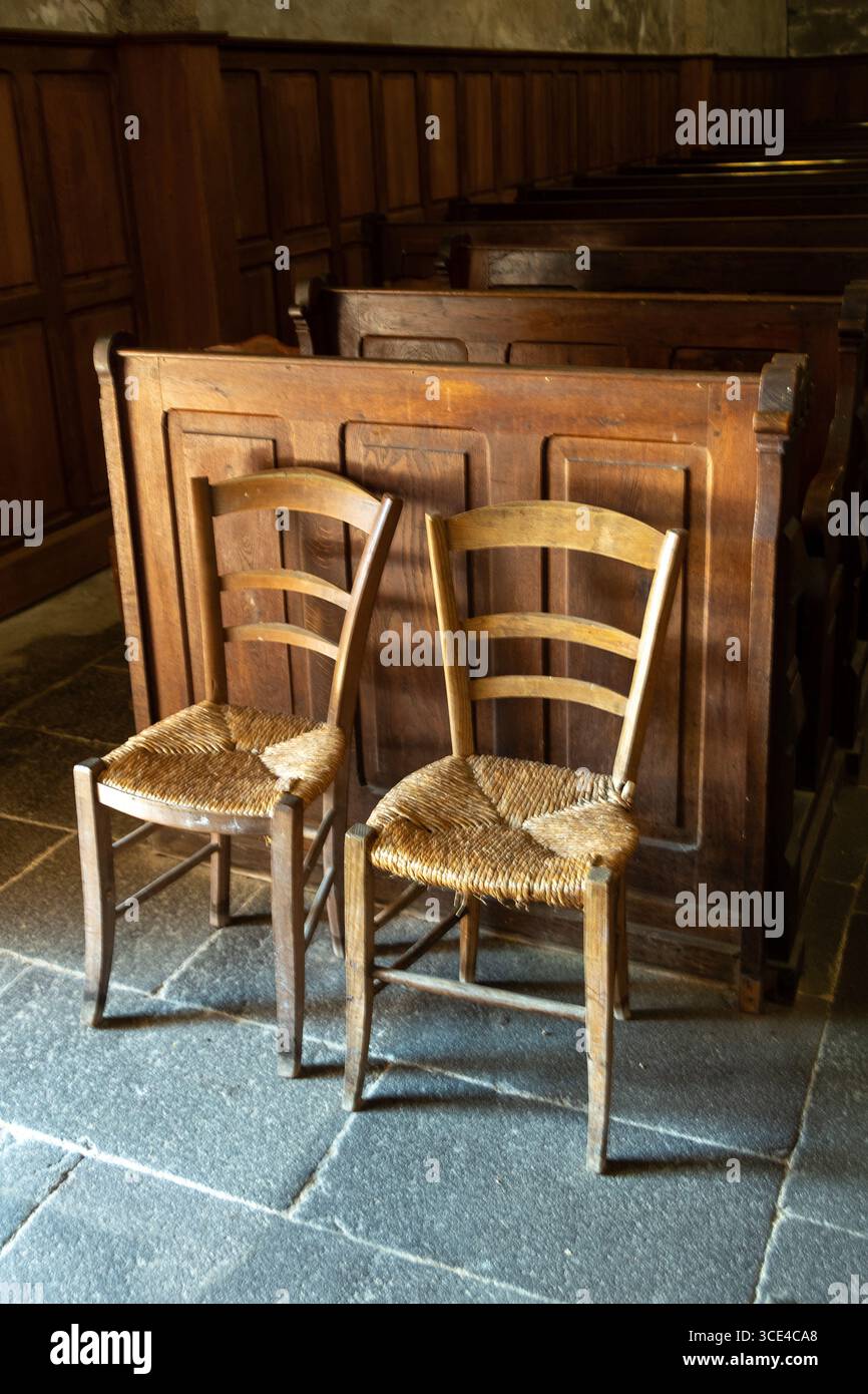 Montel de gelat. Deux chaises en bois avec des sièges tissés sont placées à l'intérieur de l'église Saint Mamert. Combrailles, Puy de Dôme, Auvergne Rhône Alpes, France Banque D'Images
