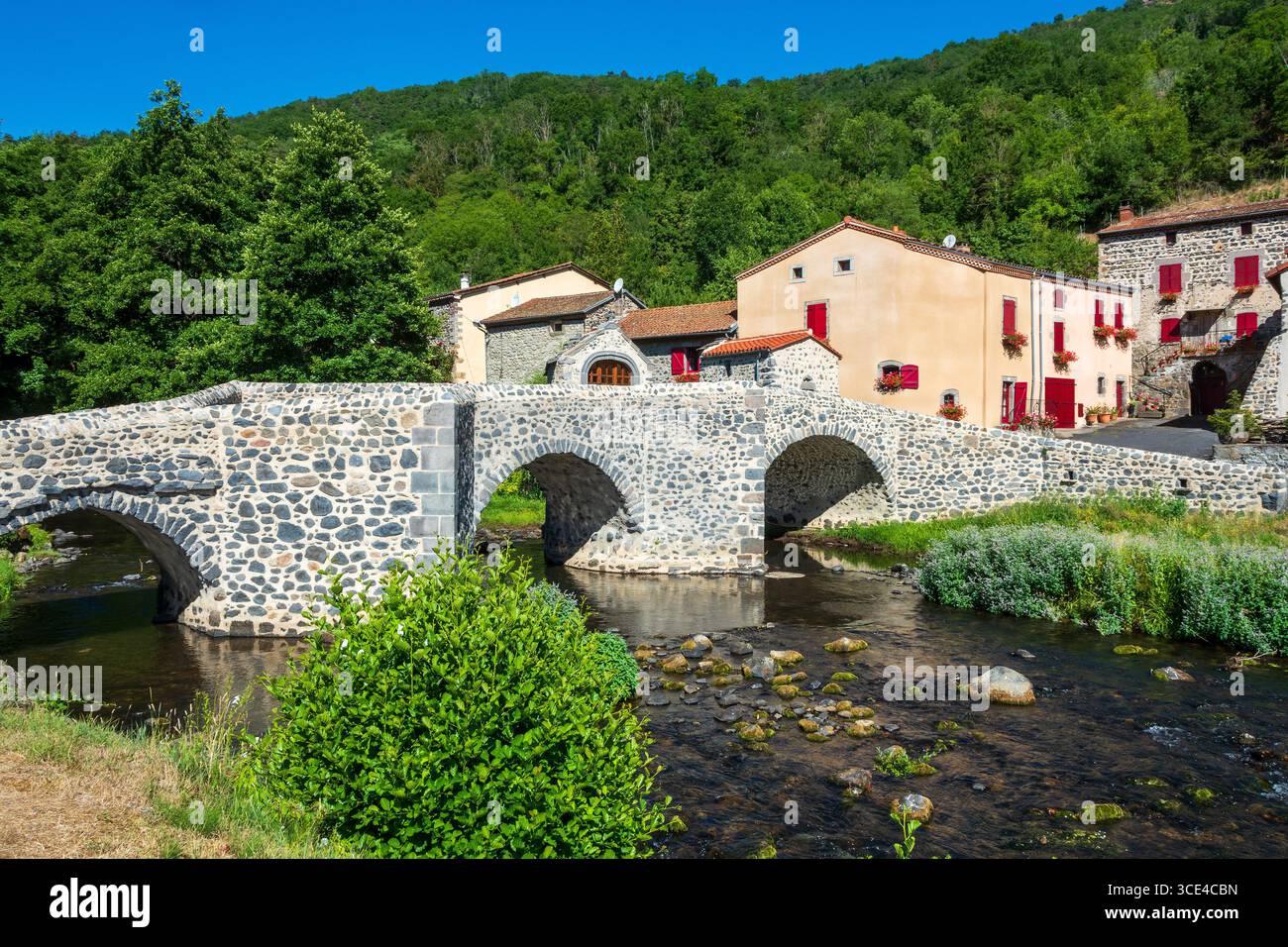 Pont en pierre sur le Pavin couze qui traverse le village de Saurier, Puy de Dome. Auvergne Rhône Alpes, France Banque D'Images