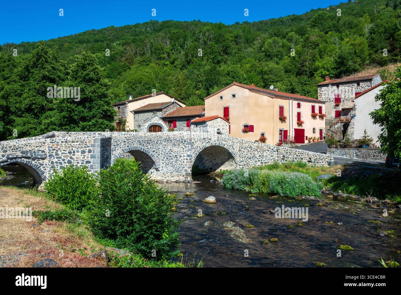 Pont en pierre sur le Pavin couze qui traverse le village de Saurier, Puy de Dome. Auvergne Rhône Alpes, France Banque D'Images