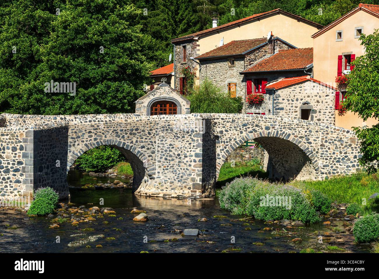 Pont en pierre sur le Pavin couze qui traverse le village de Saurier, Puy de Dome. Auvergne Rhône Alpes, France Banque D'Images