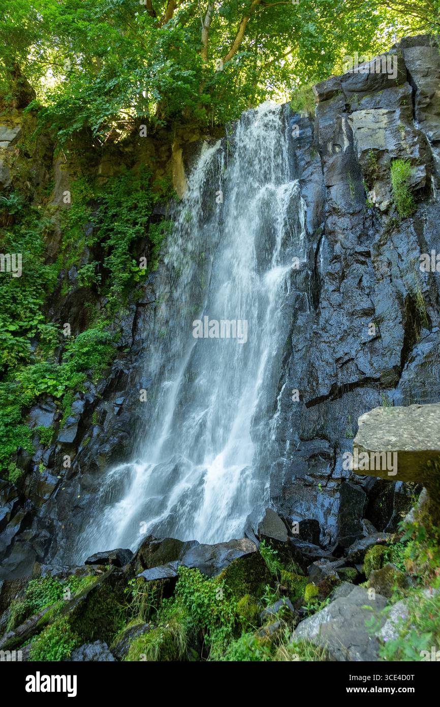 La cascade Vaucoux tombe gracieusement sur des rochers sombres, entourée d'une végétation luxuriante dans la région du Puy de Dôme. Auvergne Rhône Alpes. France Banque D'Images