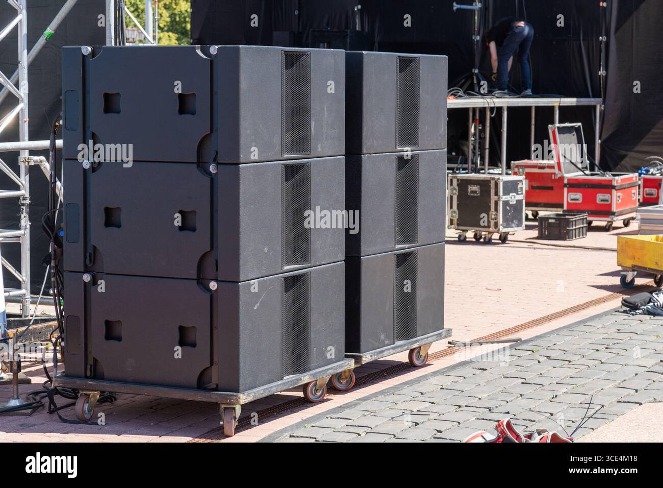 Systèmes acoustiques de concert professionnels installés sur une scène en plein air pour une performance musicale live, prêt pour un spectacle de haute énergie sous le ciel. Banque D'Images
