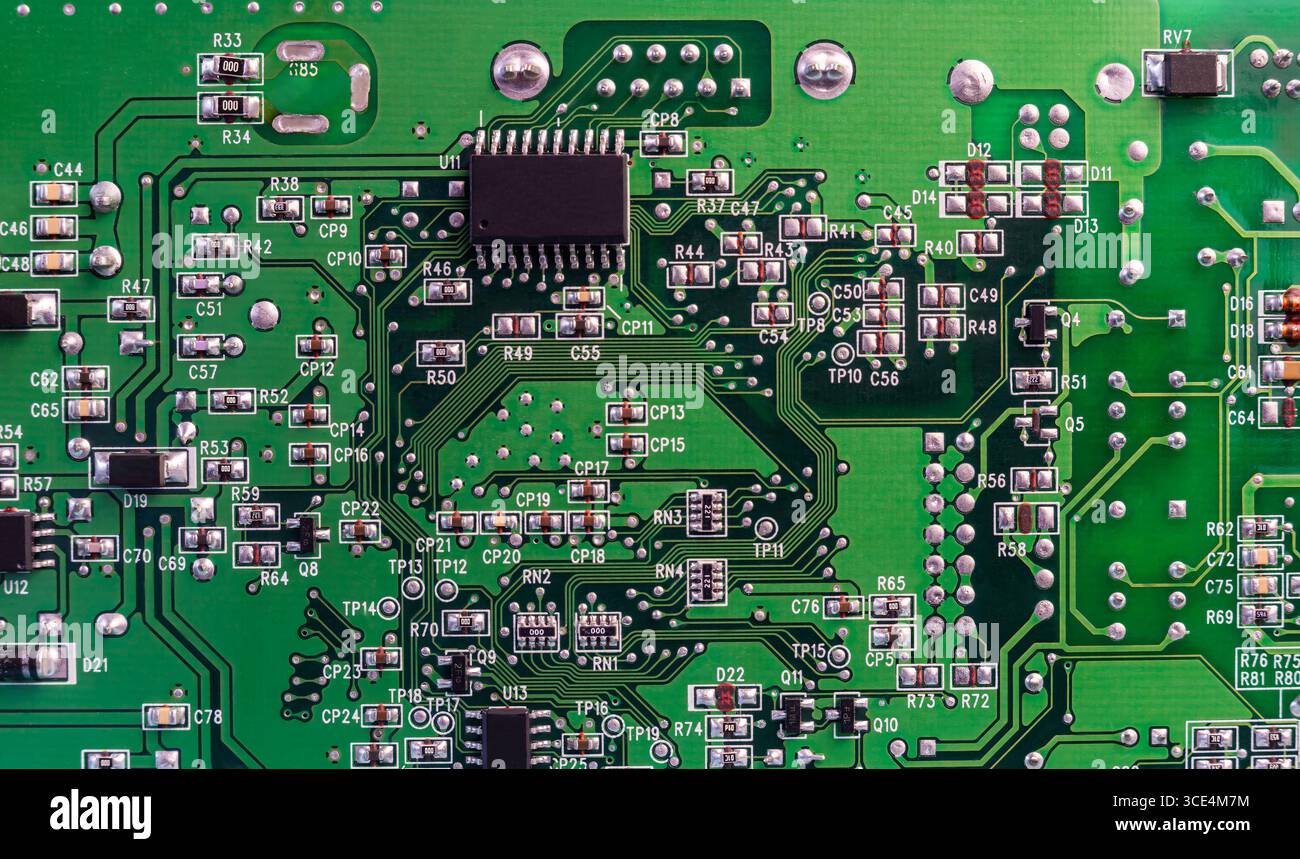 Gros plan d'une carte de circuit imprimé illustrant divers composants électroniques, tels que des résistances, des condensateurs et des connecteurs, illustrant des circuits de dispositif. Banque D'Images
