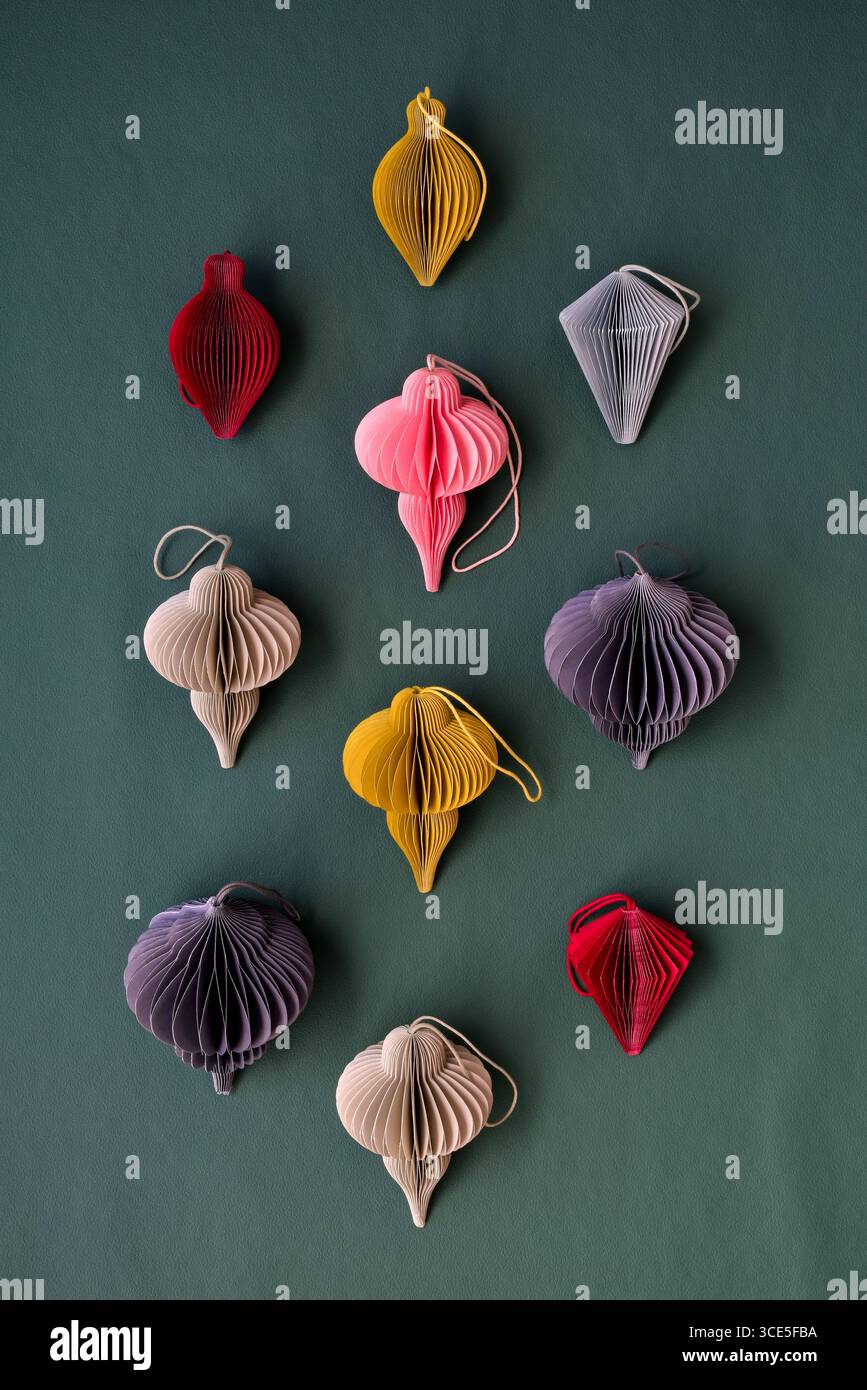 Ornements de noël en papier nid d'abeille multicolore diy faits à la main sur fond vert foncé Banque D'Images