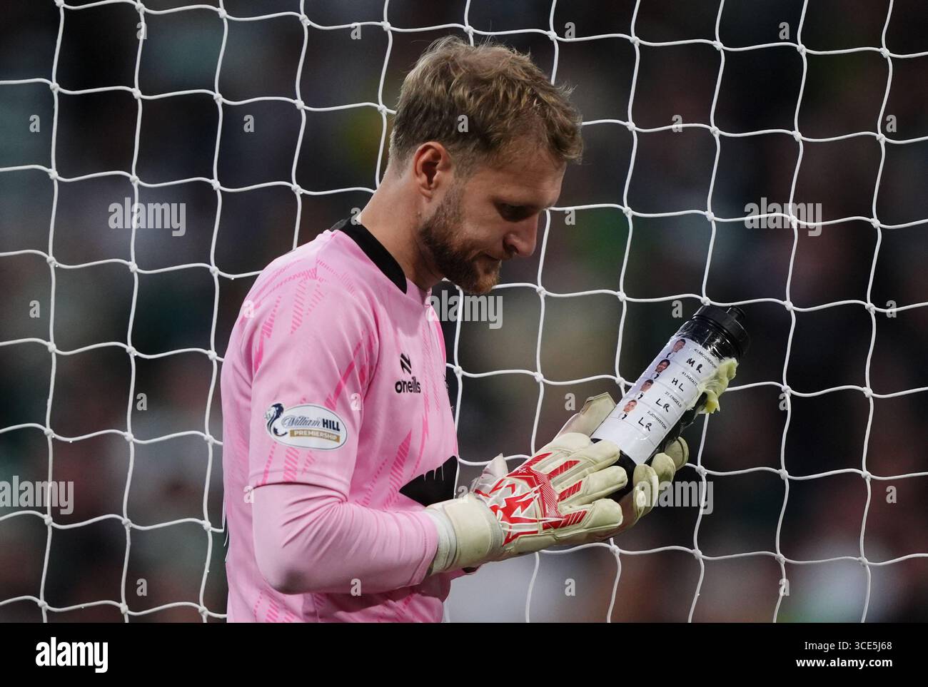 Le gardien de but de Falkirk Scott bain prend un verre dans sa bouteille d'eau, qui a les joueurs de pénalité celtique dessus, lors du match de deuxième tour de la premier Sports Cup au Celtic Park, Glasgow. Date de la photo : vendredi 15 août 2025. Banque D'Images