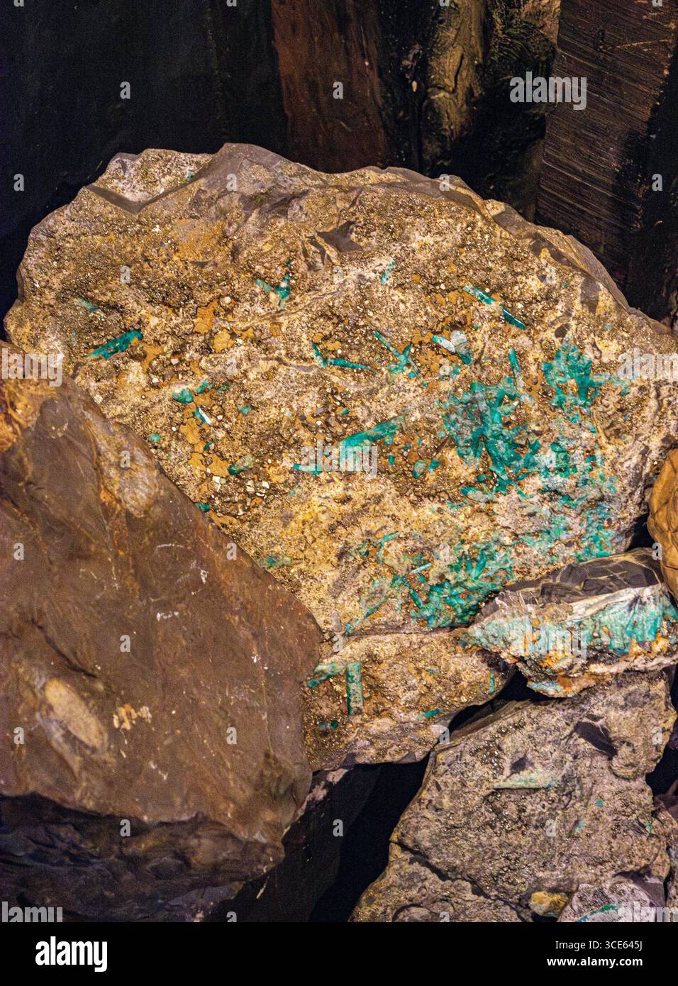 Gros plan d'un gisement minéral émeraude présentant des cristaux bleu-vert éclatants dans un cadre en pierre naturelle. Banque D'Images