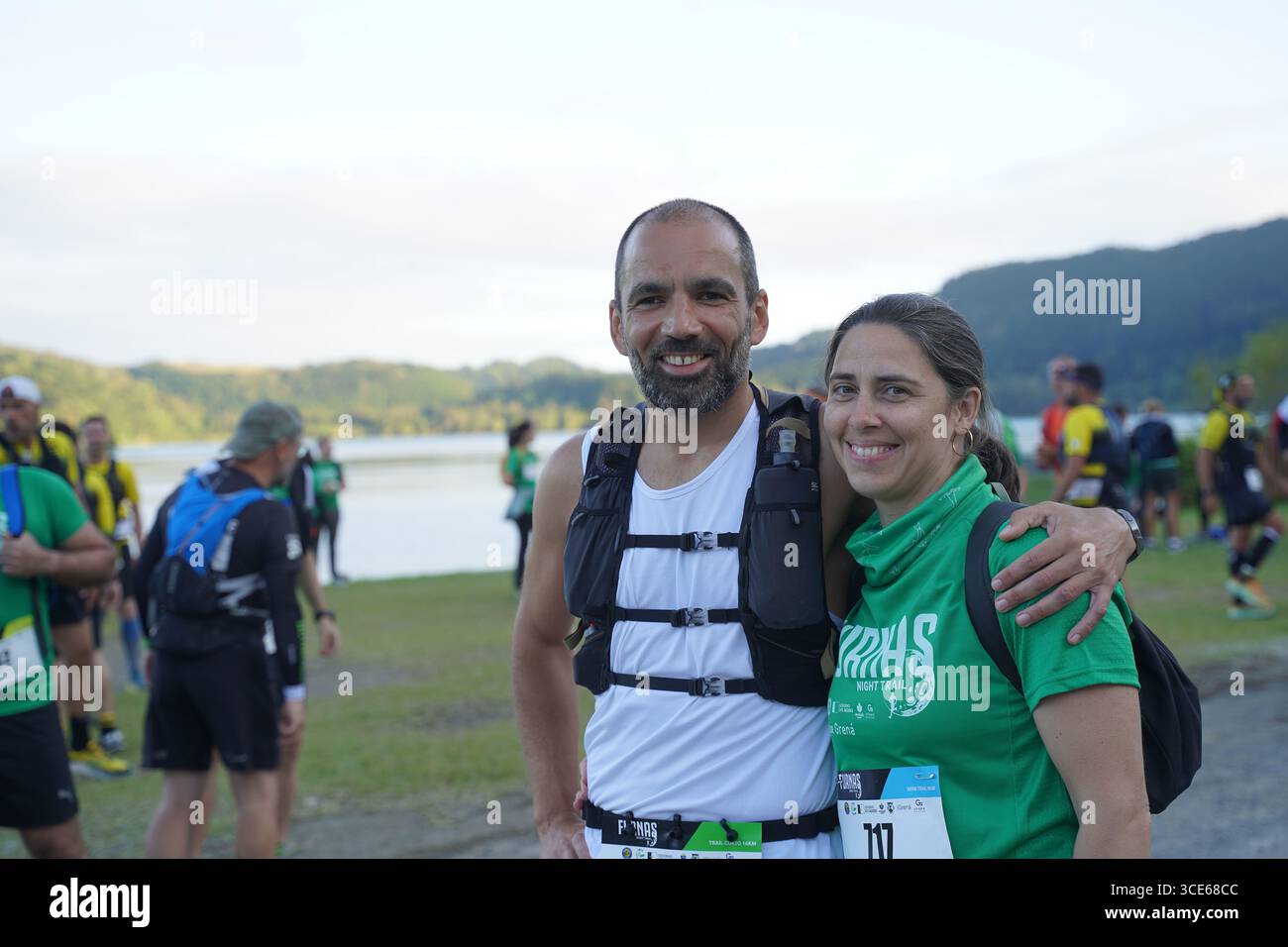 Couple d'athlètes posant avant le début de l'événement Furnas Night Trail Running aux Açores, Portugal. Banque D'Images