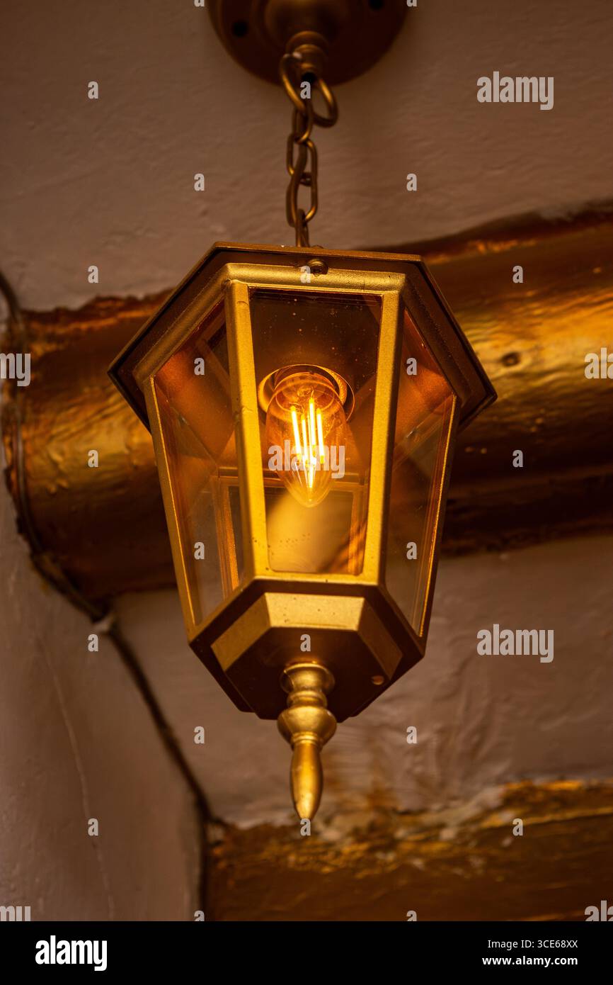 Une lanterne chaleureuse et vintage illuminant un intérieur rustique à Villa de Leyva, Boyacá, Colombie, mettant en valeur de charmants détails architecturaux. Banque D'Images
