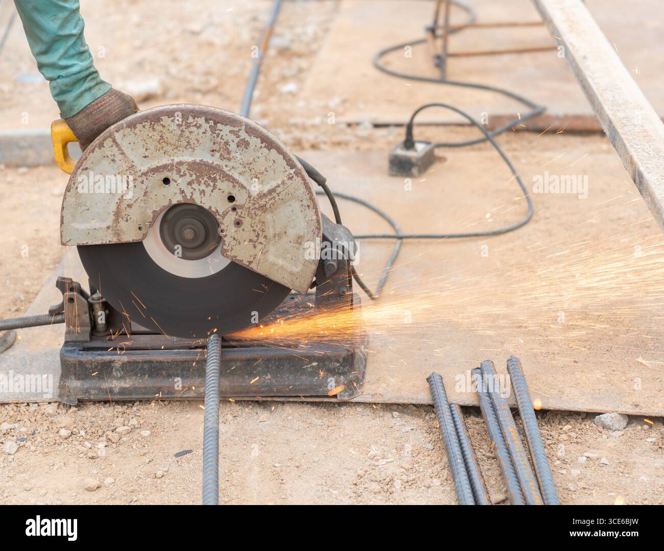 Des étincelles brillantes volent de la lame lorsqu'elle coupe à travers le métal, montrant l'intensité et la précision du travail des métaux sur un chantier de construction. Banque D'Images