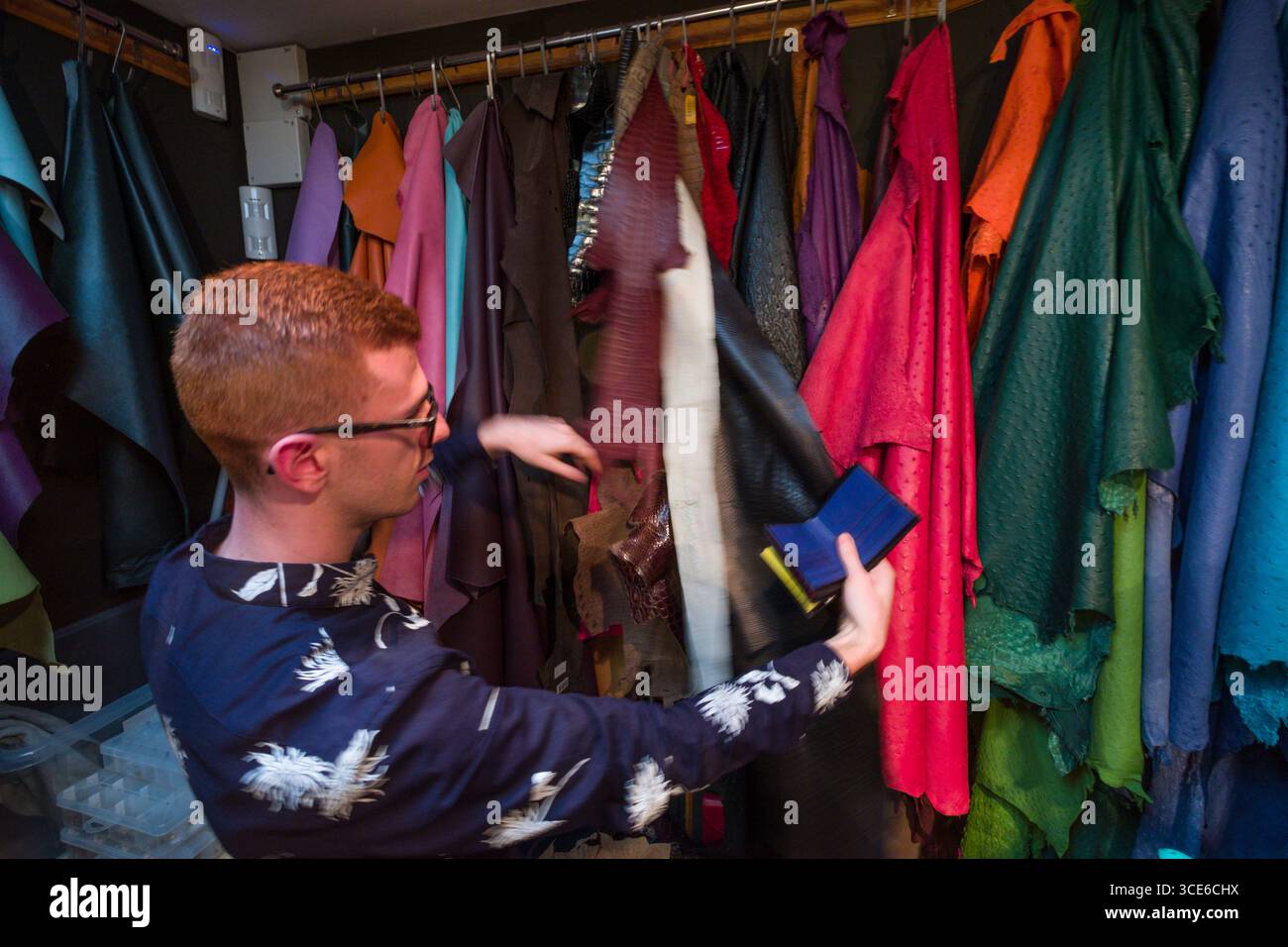 Vendeur montrant diverses couleurs et types de cuir et lizard skins intérieur Pickett Londres, fournisseur de produits de luxe en cuir fait main, Mayfair, Ville Banque D'Images