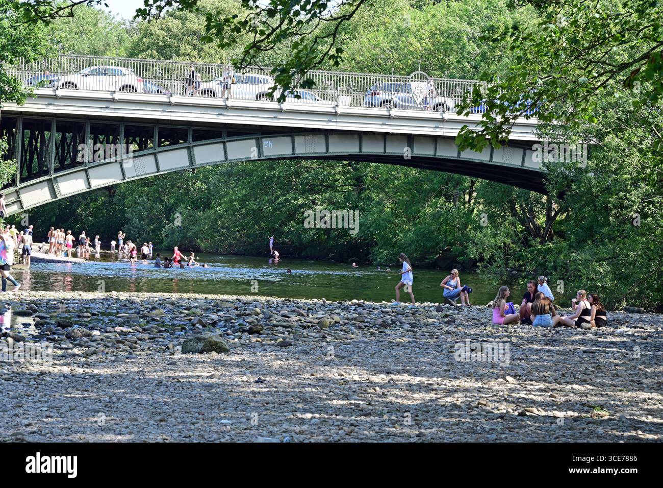 Ilkley, les gens jouant dans la rivière Wharfe, Riverside Gardens, dans Summer Sunshine, Yorkshire, Angleterre Banque D'Images