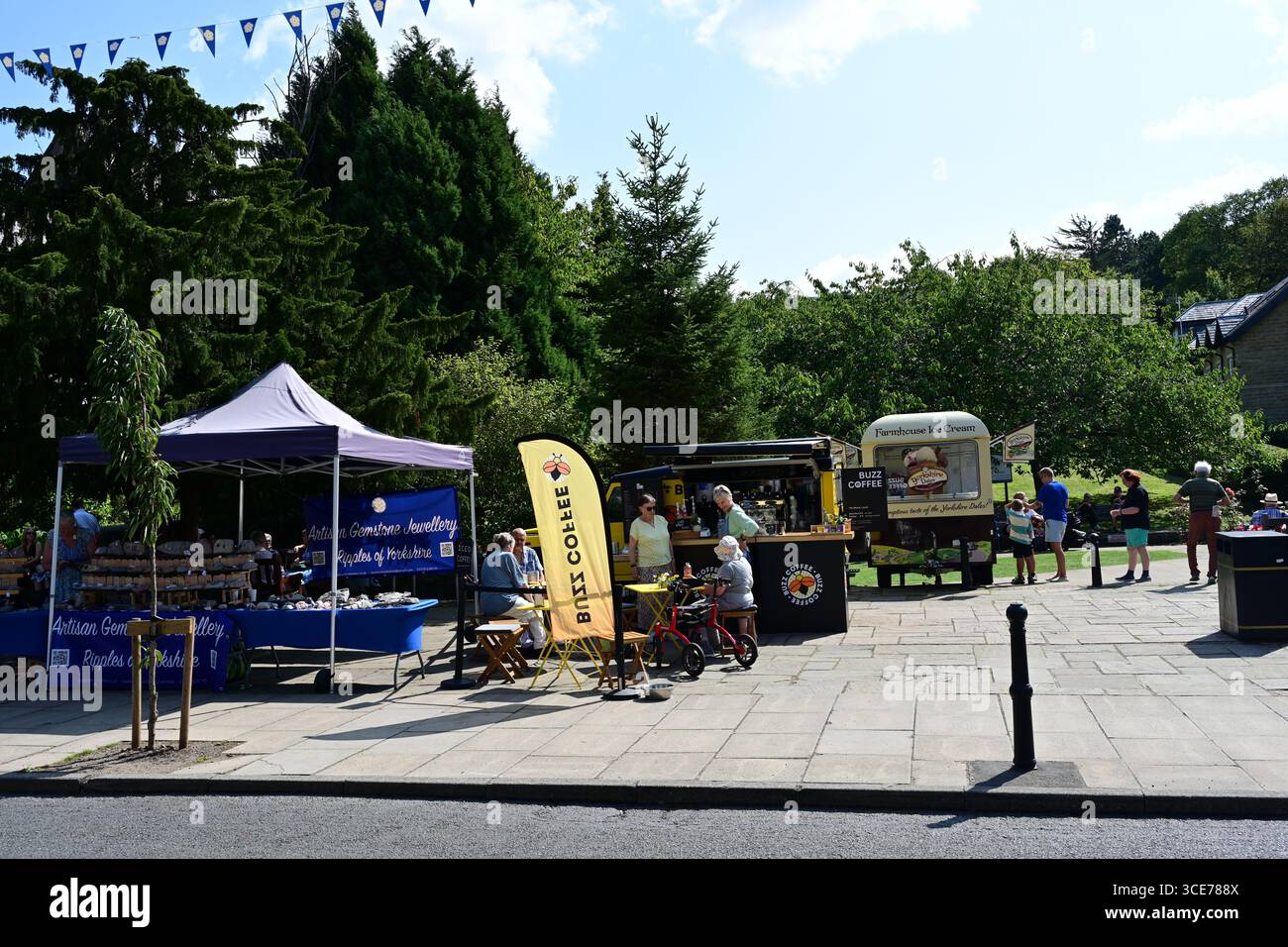 Les gens dans le centre-ville d'Ilkley avec fourgonnette de crème glacée et des sièges, dans le soleil d'été, Yorkshire Banque D'Images