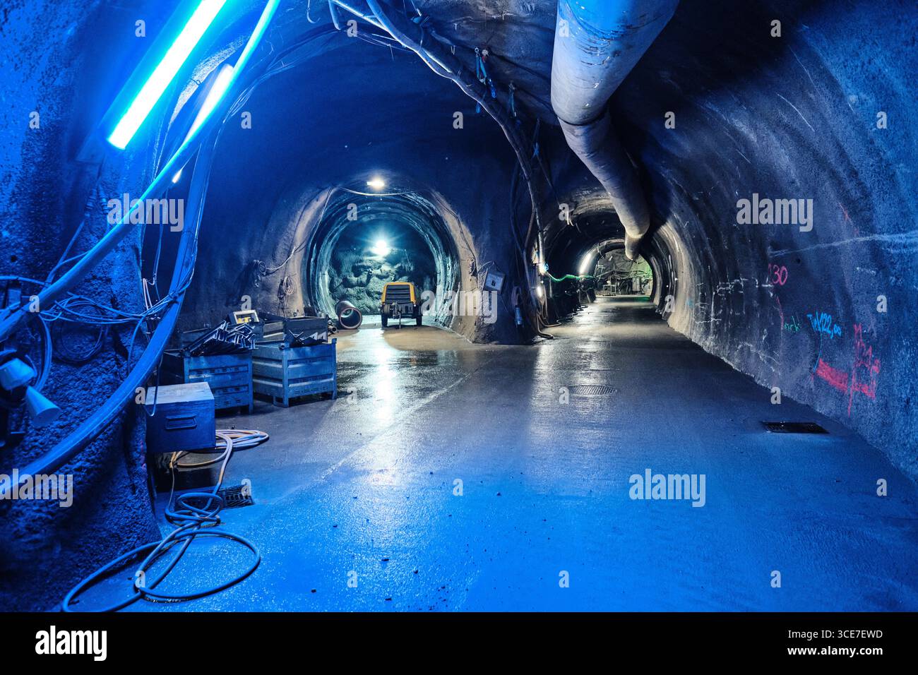 Tunnel souterrain avec éclairage, tuyaux de ventilation et matériel de construction Banque D'Images