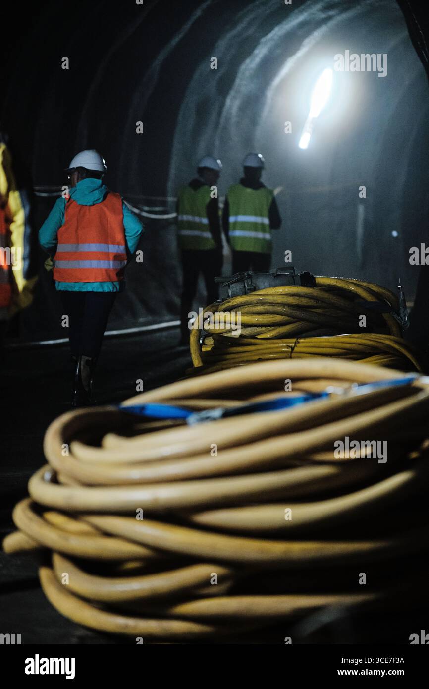 Ouvriers à l'intérieur du tunnel d'eau hydroélectrique avec des câbles Banque D'Images