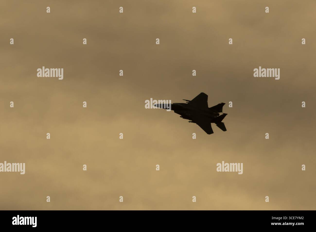 McDonnell Douglas F-15E Strike Eagle avion militaire de chasse de l'armée de l'air des États-Unis USAF en silhouette de vol au coucher du soleil à RAF Lakenheath ai Banque D'Images
