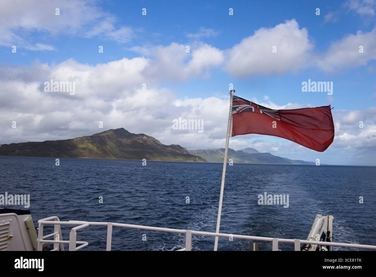Regardant au nord depuis un bateau se dirigeant vers le sud dans le Sound of Raasay entre Skye et Raasay, Hébrides intérieures, Écosse, avec la mer bleue, nuages blancs, et t Banque D'Images