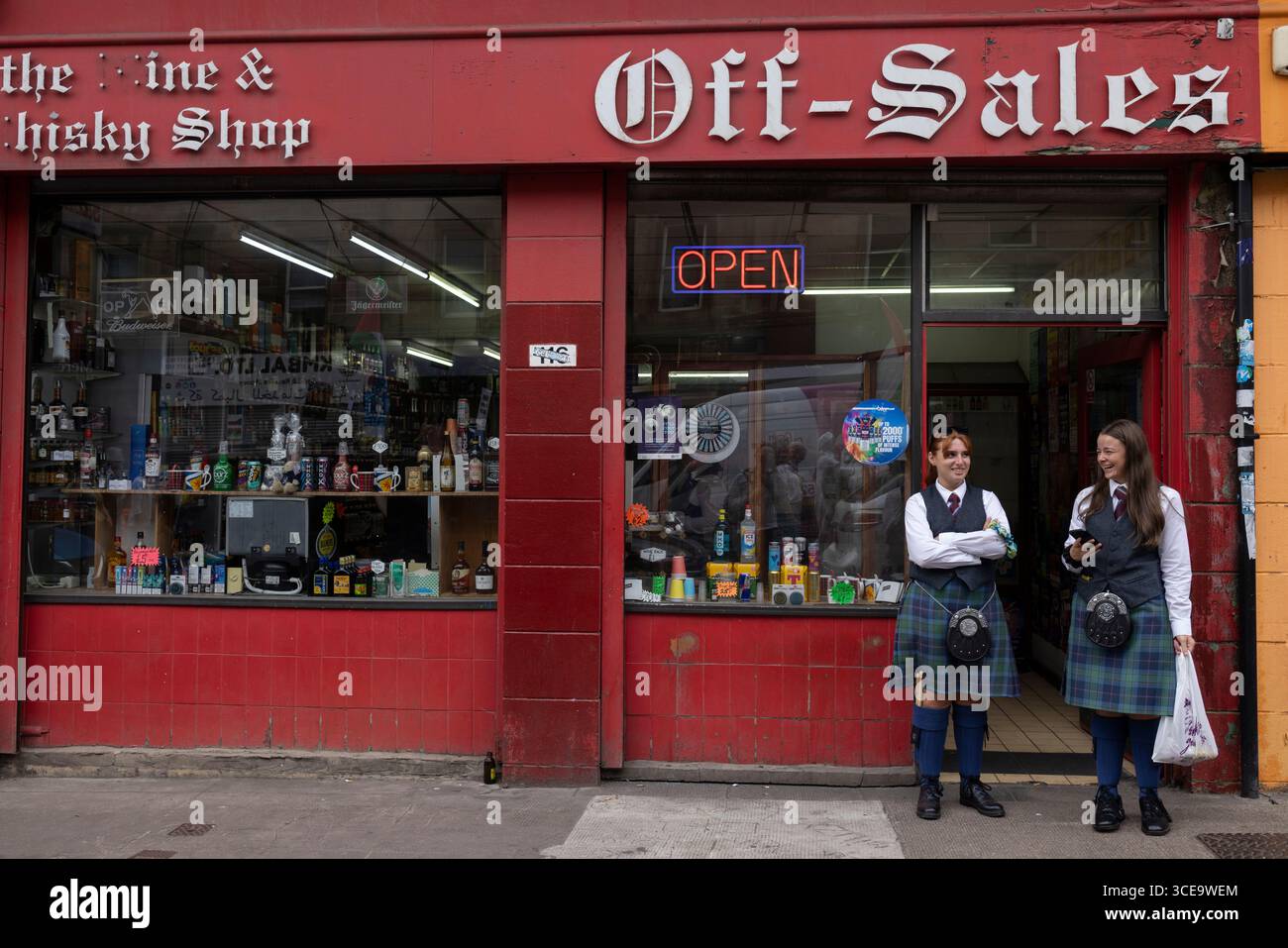 Glasgow, Royaume-Uni, 16 août 2025. Les membres de la pipe band quittent un magasin d'alcool hors-vente, dans le district de Trongate, à Glasgow, en Écosse, le 16 août 2025. Banque D'Images