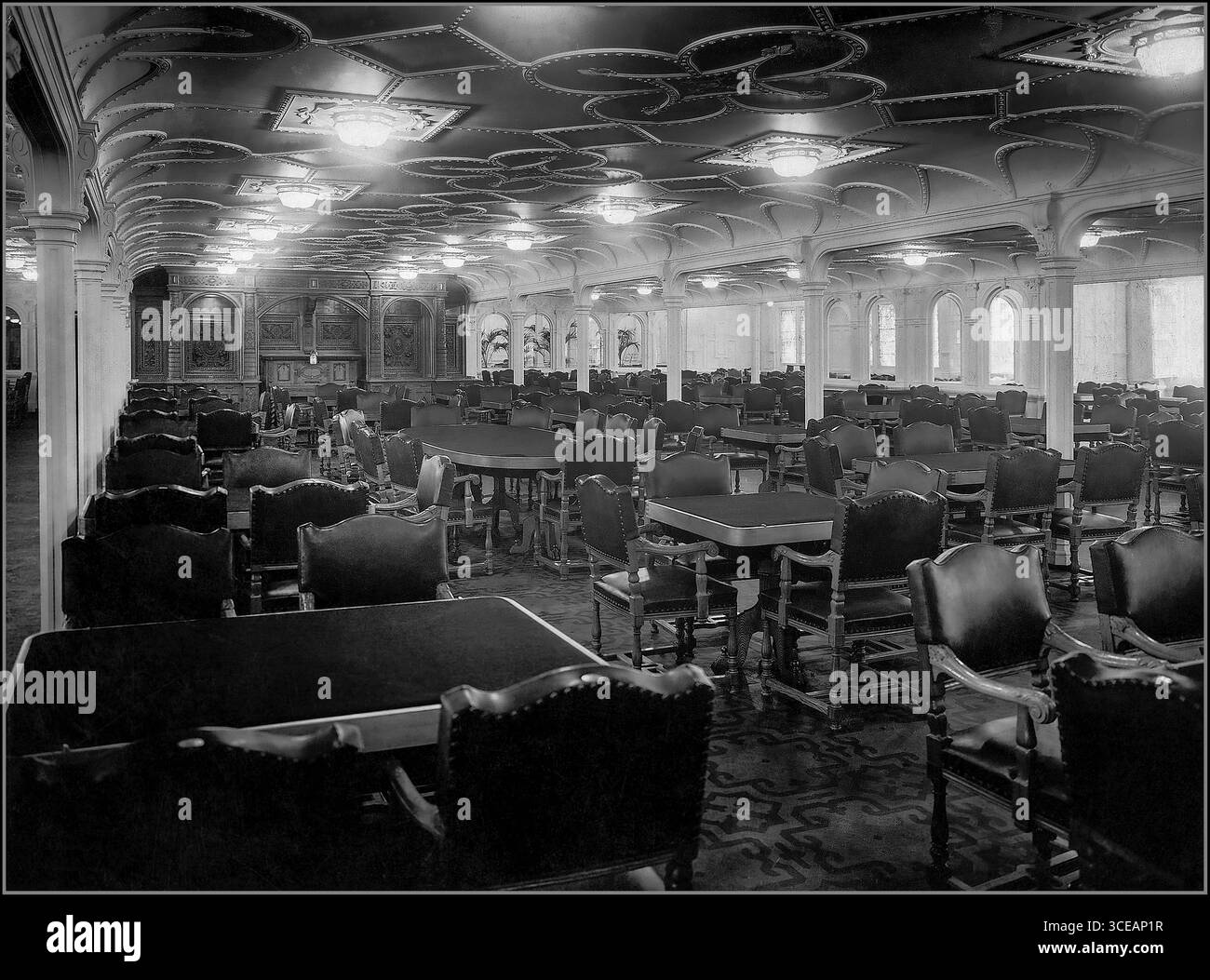 Salle à manger de première classe de la LIGNE ÉTOILE BLANCHE du RMS OLYMPIC à bord du RMS Olympic, 1911 – navire frère du Titanic » cette photographie de 1911 présente la salle à manger de première classe à bord du RMS Olympic, le navire frère du tristement célèbre RMS Titanic. Cette impressionnante salle à manger était située sur d-Deck et pouvait accueillir 532 passagers, ce qui en faisait la plus grande salle à manger jamais vue sur un navire à l'époque. La chambre était décorée dans le style jacobéen, peinte dans une couleur blanche arachide, avec des chaises en chêne et des tables conçues pour le luxe et le confort. Belfast 1911 Banque D'Images