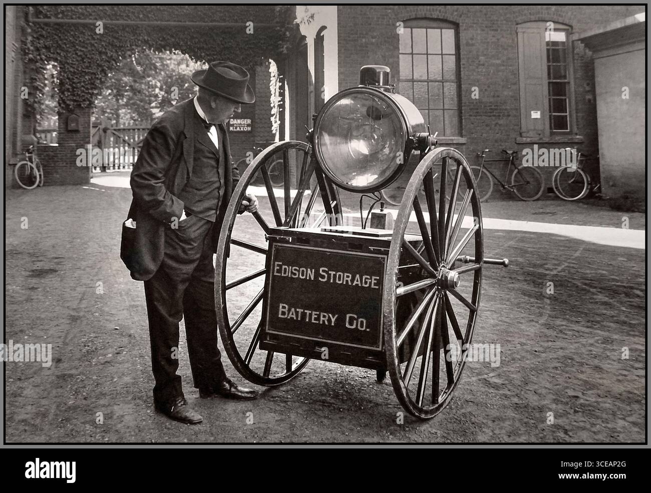 « Thomas A. Edison visionnaire et inventeur avec son chariot Searchlight et sa batterie de stockage, 1915. Cette unité d'éclairage mobile expérimentale reflète le travail en cours d'Edison avec l'éclairage électrique et les systèmes de batterie avancés au début du XXe siècle. » Banque D'Images