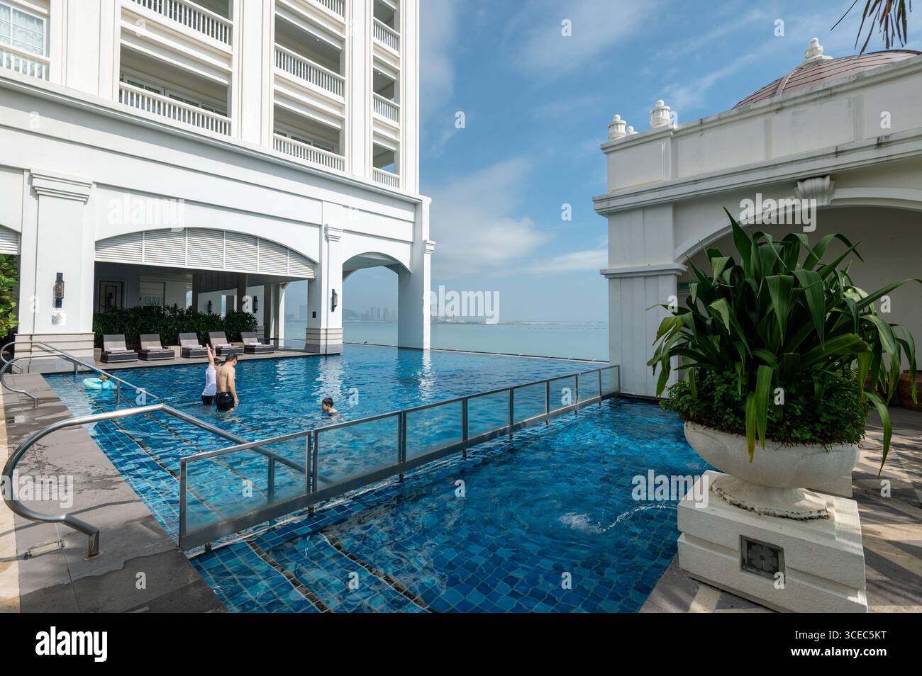 Les clients de l'hôtel apprécient une baignade en milieu de matinée à l'hôtel Eastern & Orient, face à la mer, dans la ville historique de George Town, Penang, Malaisie. Banque D'Images