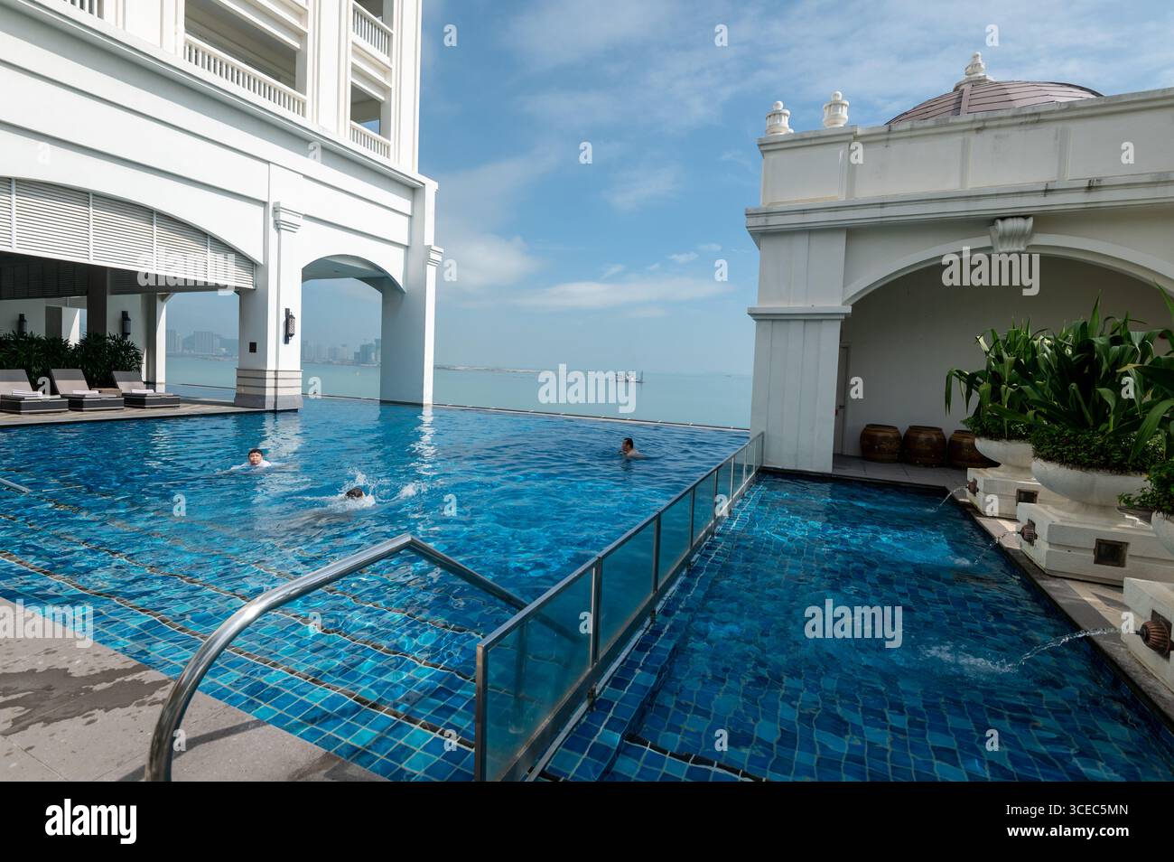 Les clients de l'hôtel apprécient une baignade en milieu de matinée à l'hôtel Eastern & Orient, face à la mer, dans la ville historique de George Town, Penang, Malaisie. Banque D'Images
