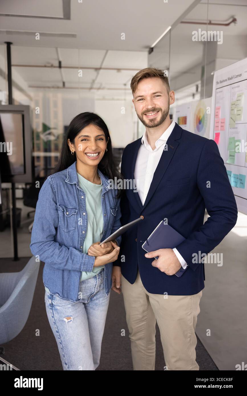 Deux jeunes collègues d'affaires multiethniques heureux posant pour un portrait d'affaires Banque D'Images