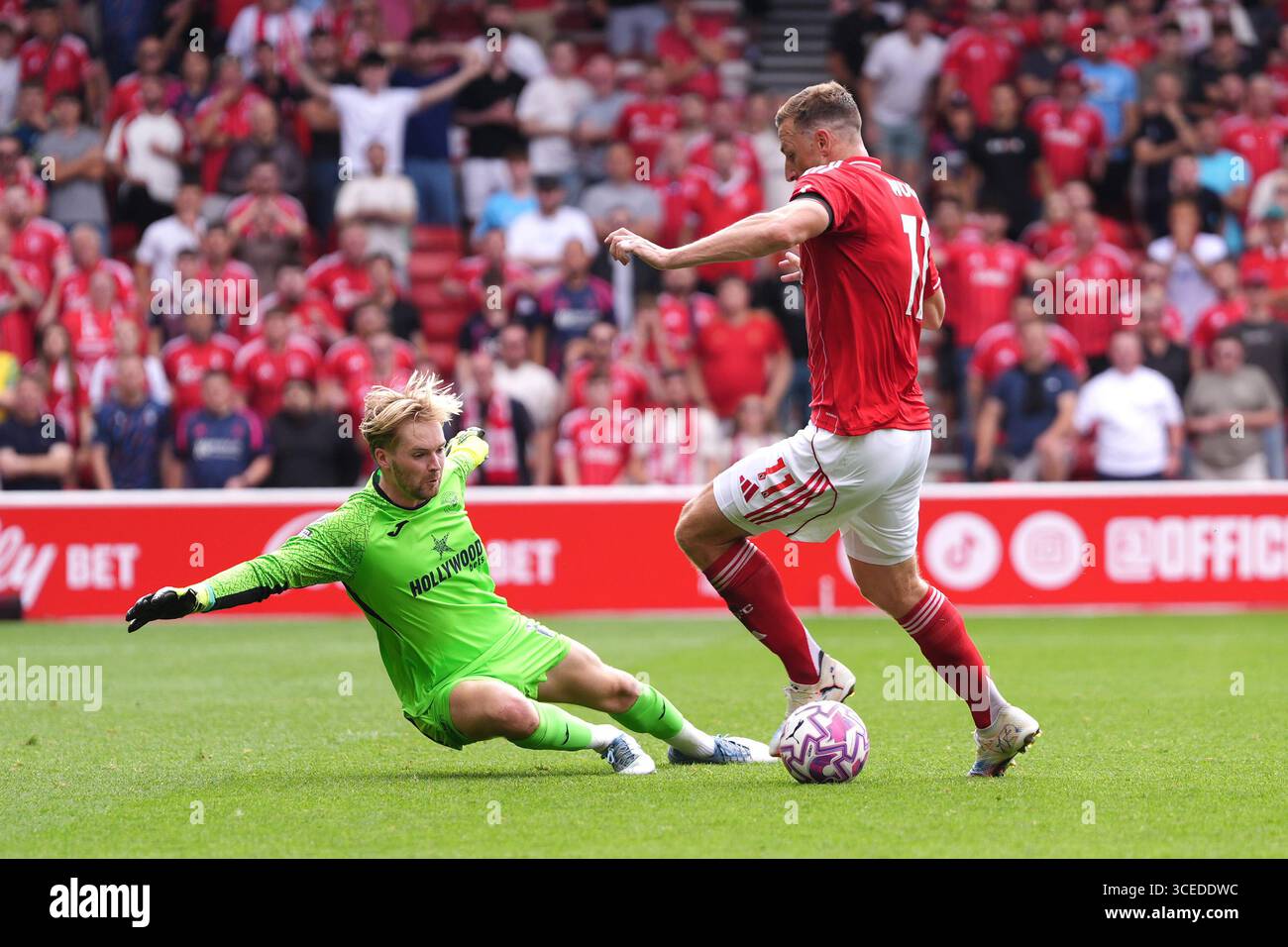 Chris Wood de Nottingham Forest (à droite) dépasse le gardien de Brentford Caoimhin Kelleher pour marquer le troisième but de son équipe lors du match de premier League au City Ground, Nottingham. Date de la photo : dimanche 17 août 2025. Banque D'Images