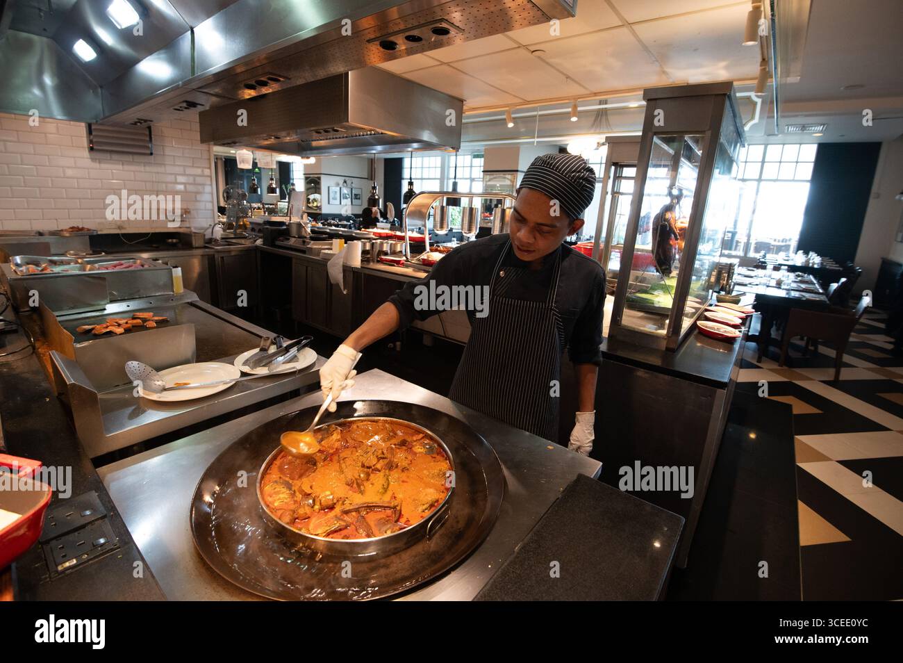 Un chef d'hôtel préparant un plat oriental dans le restaurant Sarkies, connu pour ses buffets, à l'hôtel Eastern & Orient à George Town, capitale Banque D'Images