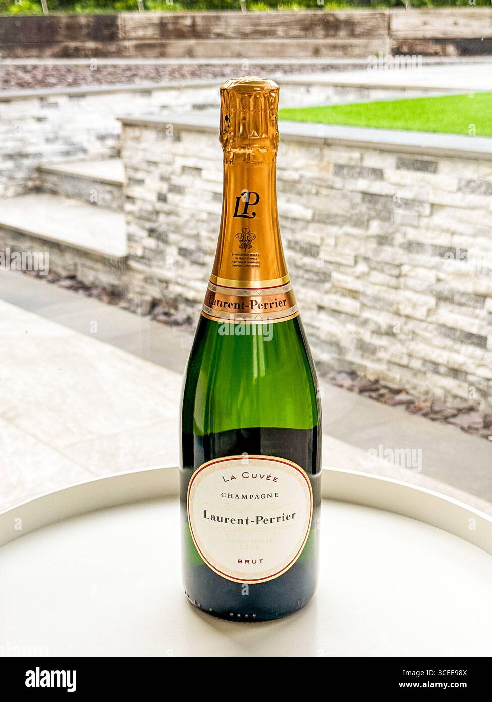 Cardiff, pays de Galles, Royaume-Uni - 1er mai 2025 : bouteille non ouverte de champagne Laurent-Perrier la Cuvee sur une table dans le jardin d'une maison - Image de stock capturée avec un smartphone