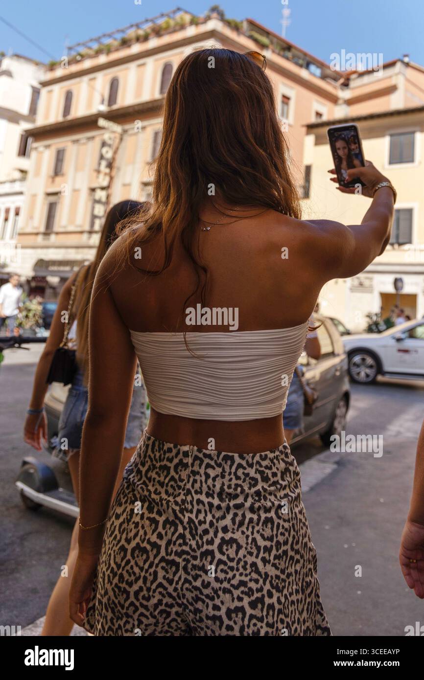 Jeune femme prenant un selfie dans la rue, Rome, Italie Banque D'Images