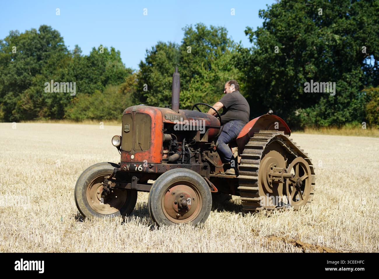 Agriculteur utilisant un tracteur d'époque dans les champs pendant le labourage. Labourage Vintage, Rousham, Angleterre Banque D'Images
