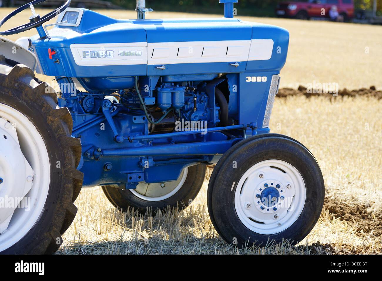 Gros plan du tracteur Classic Blue dans un champ sous ciel dégagé. Labourage Vintage, Rousham, Angleterre Banque D'Images