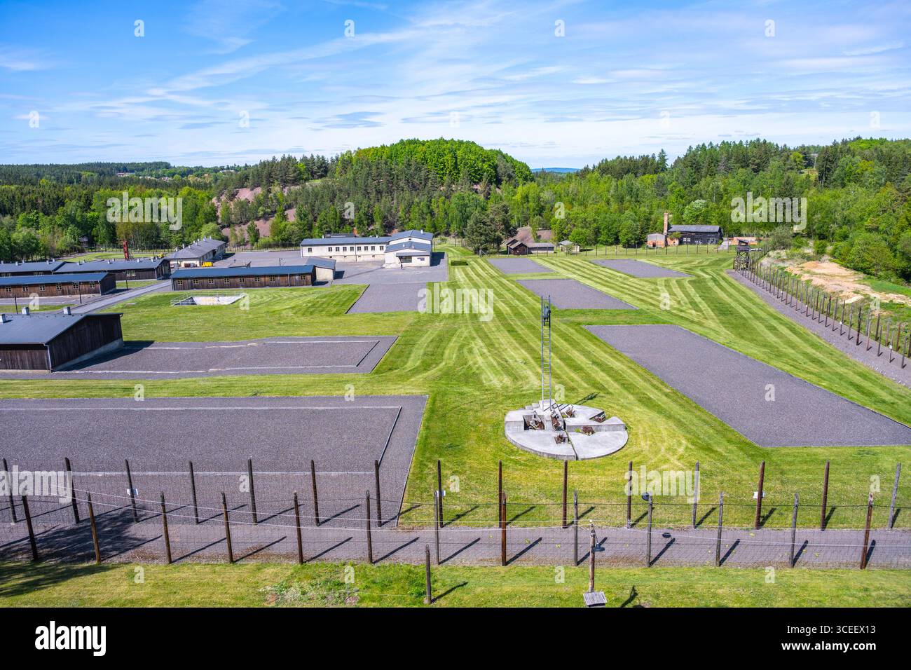 Ce mémorial de Lesetice rend hommage aux victimes du communisme, mettant en valeur un ancien complexe pénitentiaire entouré de paysages verdoyants et de terrains soigneusement entretenus sous un ciel dégagé. Banque D'Images