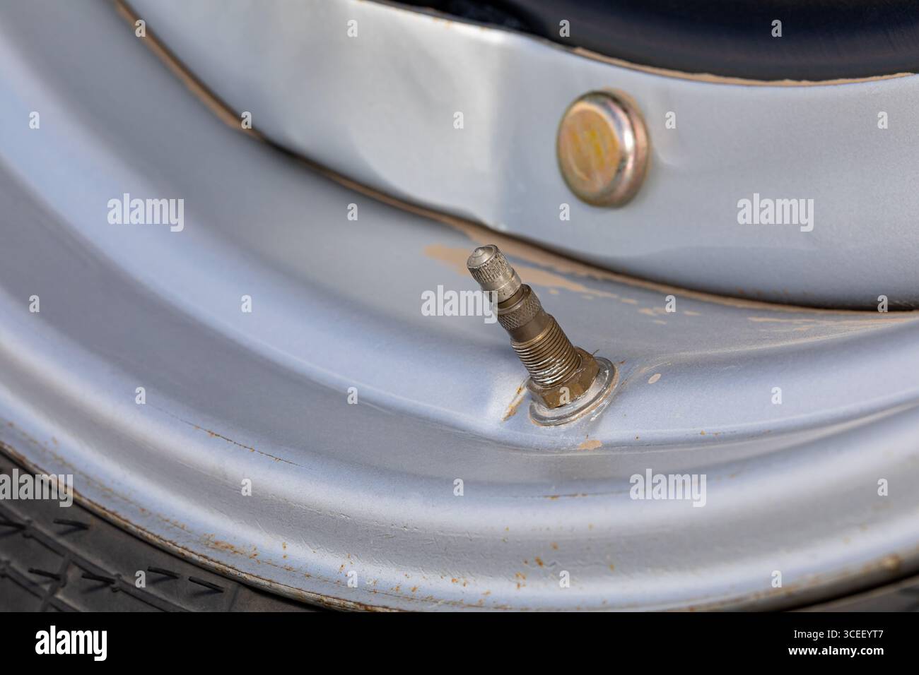 Tige de valve sur pneu de tracteur agricole. Pression des pneus, compactage du sol, entretien et réparation des équipements agricoles. Banque D'Images