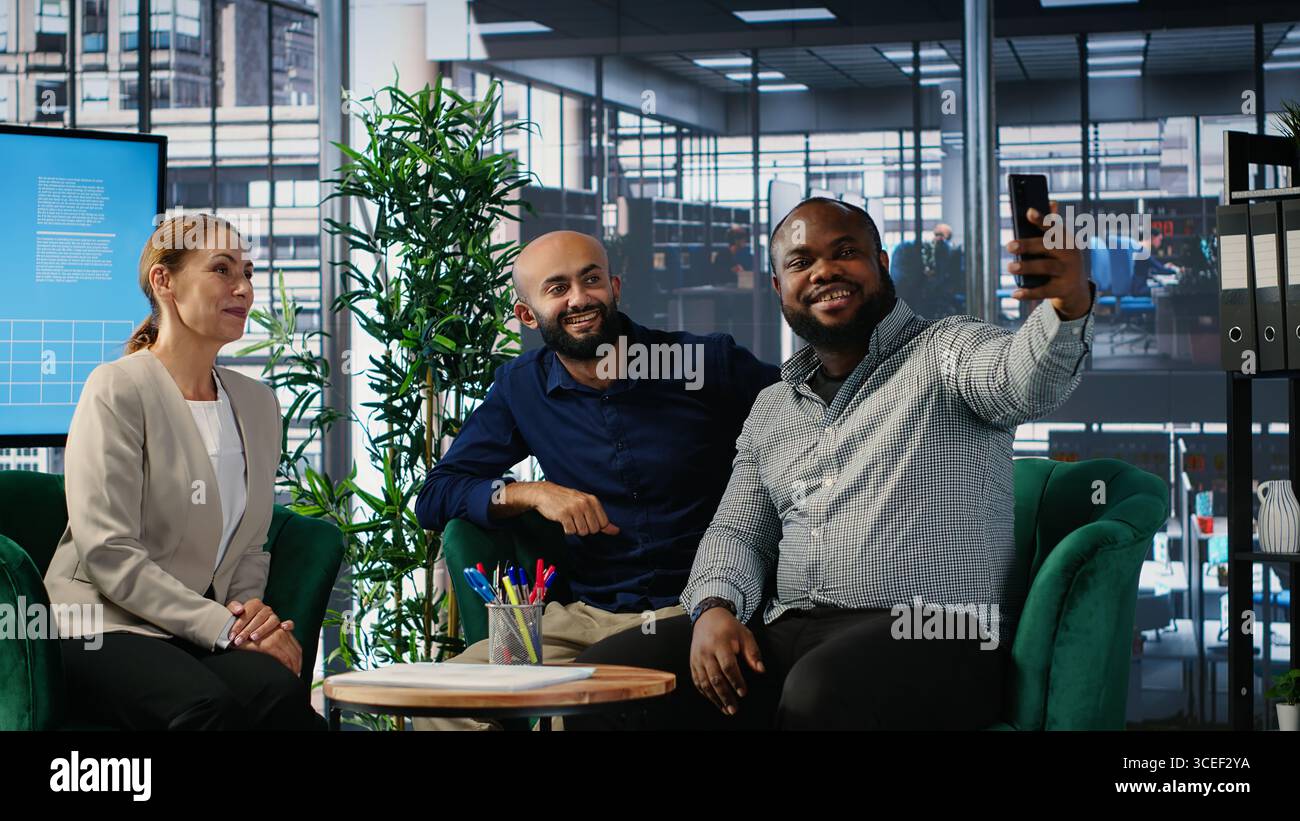 Des gens d'affaires multiethniques scellent leur partenariat avec une photo sur les médias sociaux, parvenant à un accord verbal pour une nouvelle collaboration internationale. Les PDG prennent des photos sur les plateformes médiatiques. Caméra B. Banque D'Images