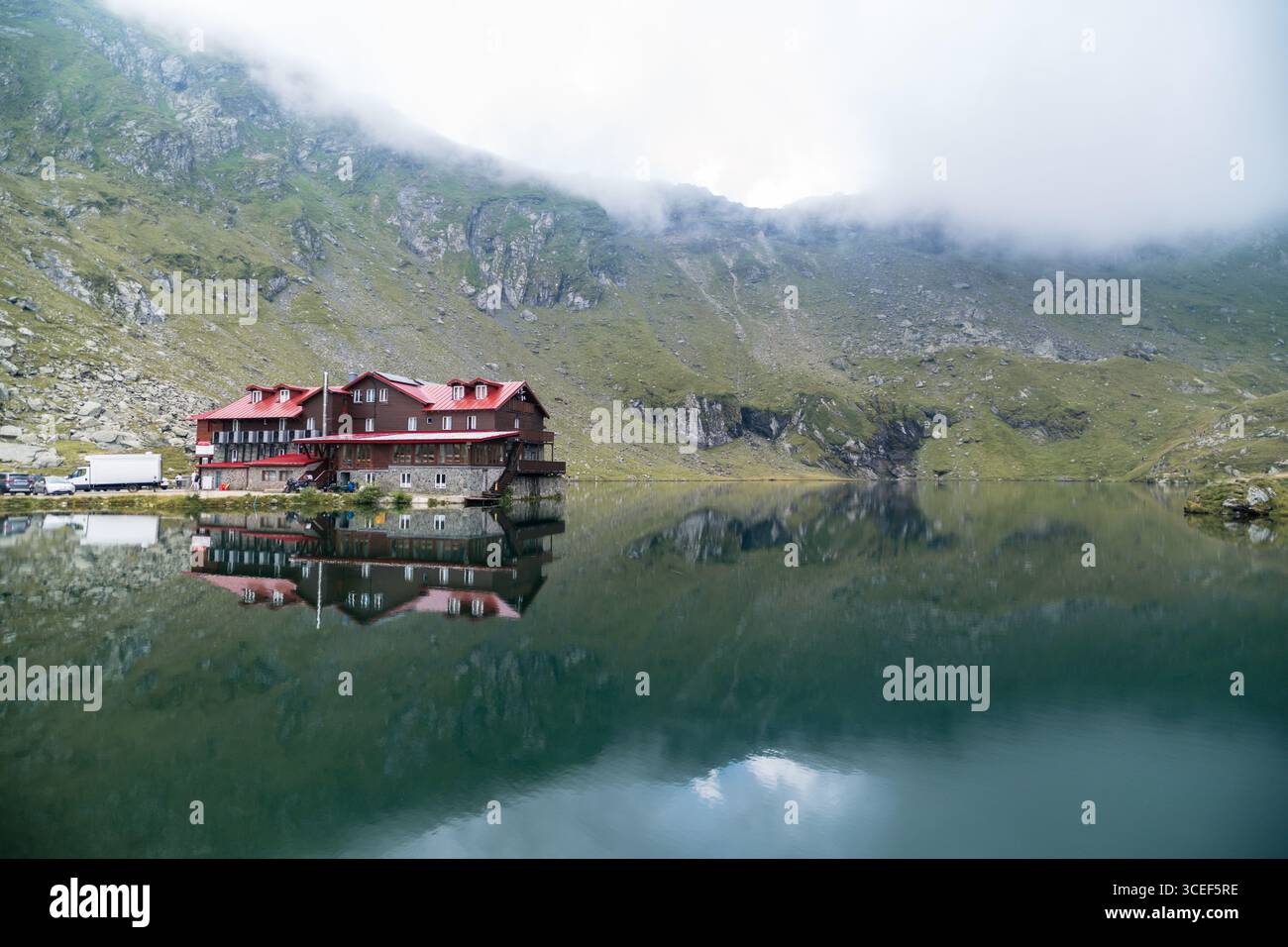 Chalet du lac Balea reflétant dans l'eau calme d'un lac de montagne Banque D'Images