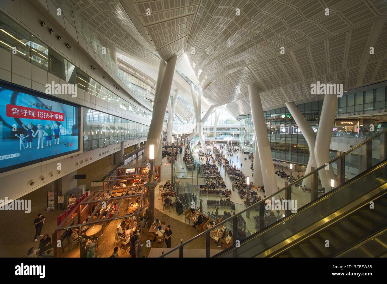 À l'intérieur de la gare de Hong Kong West Kowloon pour le train à grande vitesse, avec une architecture futuriste, des zones d'attente spacieuses pour les passagers, des magasins et des restaurants. Banque D'Images