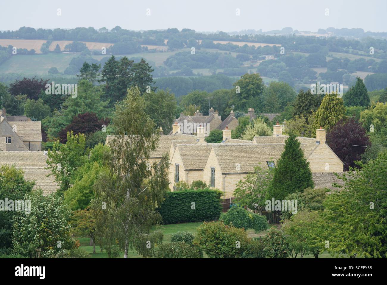 Village anglais tranquille avec verdure luxuriante et maisons traditionnelles en pierre. Bourton-on-the-Water, Angleterre Banque D'Images