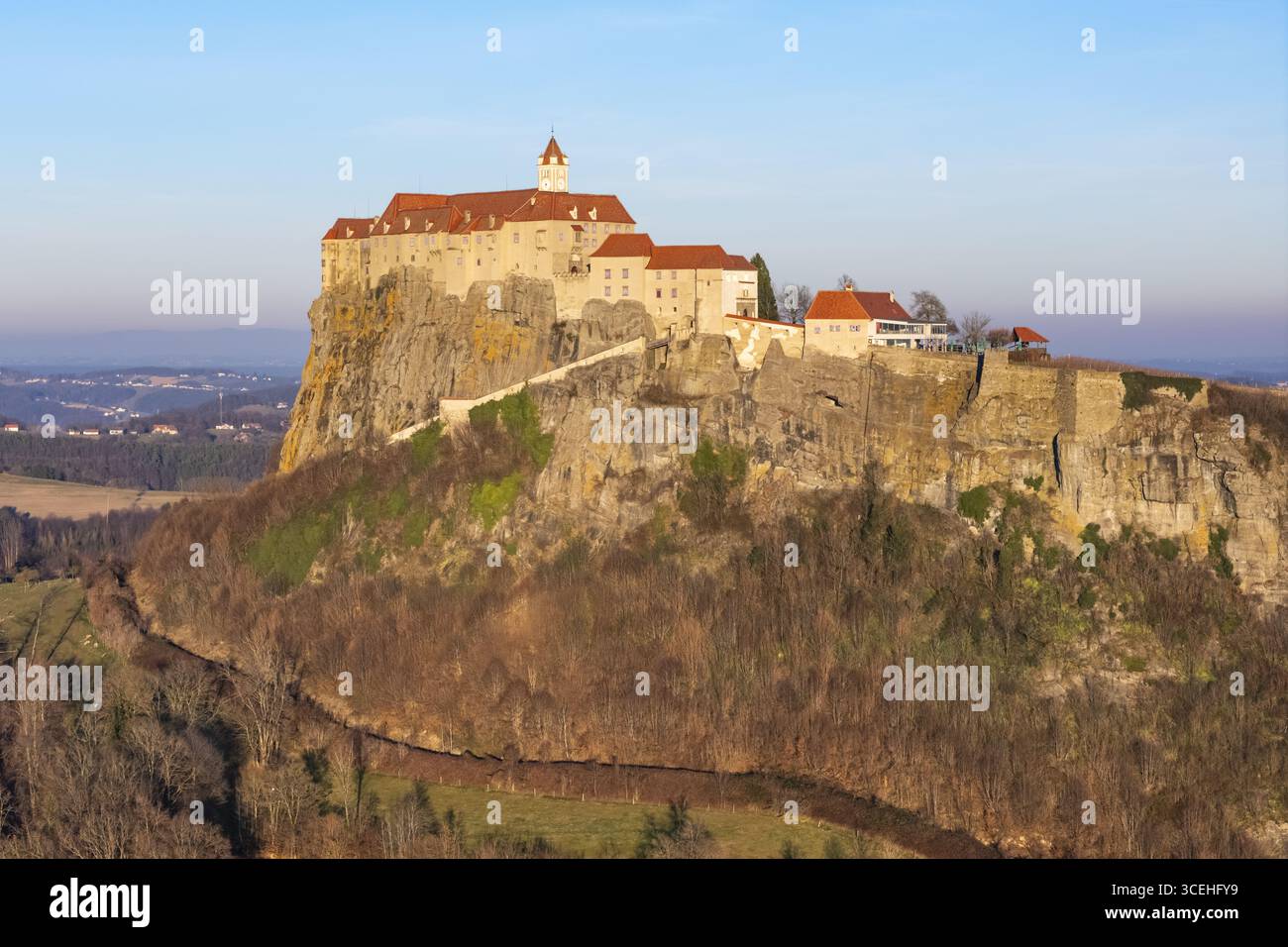 Vue aérienne du majestueux château de Riegersburg perché au sommet d'une roche volcanique, baigné dans la lueur chaude du soleil couchant, Riegersburg, Steiermark, Autriche. Banque D'Images