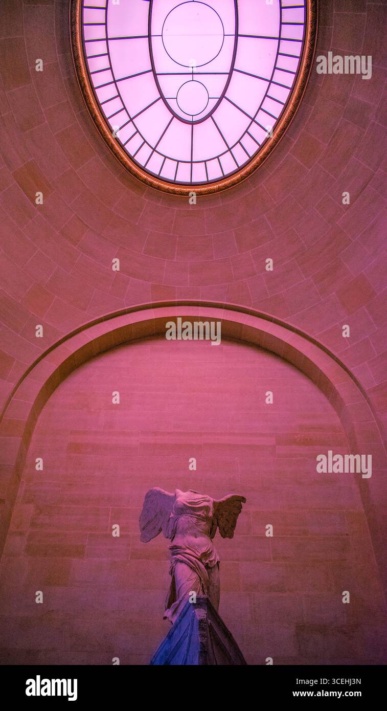 Paris : Musée du Louvre, lumière rose sur la victoire ailée de Samothrace, ou Nike de Samothrace, chef-d'œuvre de la sculpture grecque de l'époque hellénistique Banque D'Images